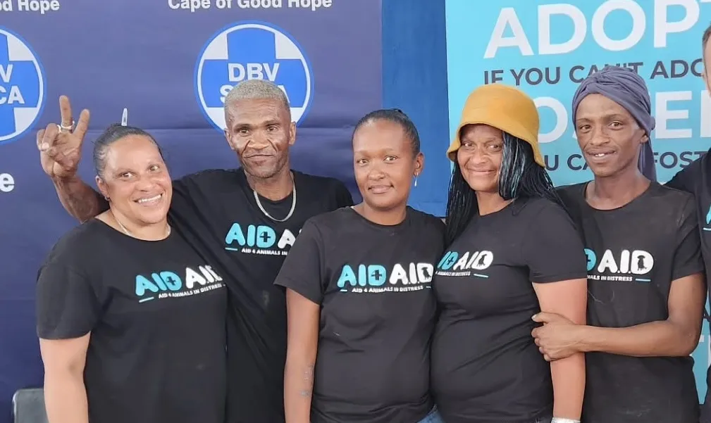 Aid4Aid field workers in branded shirts at a sterilisation day, in front of the Aid4Aid and SPCA banners.